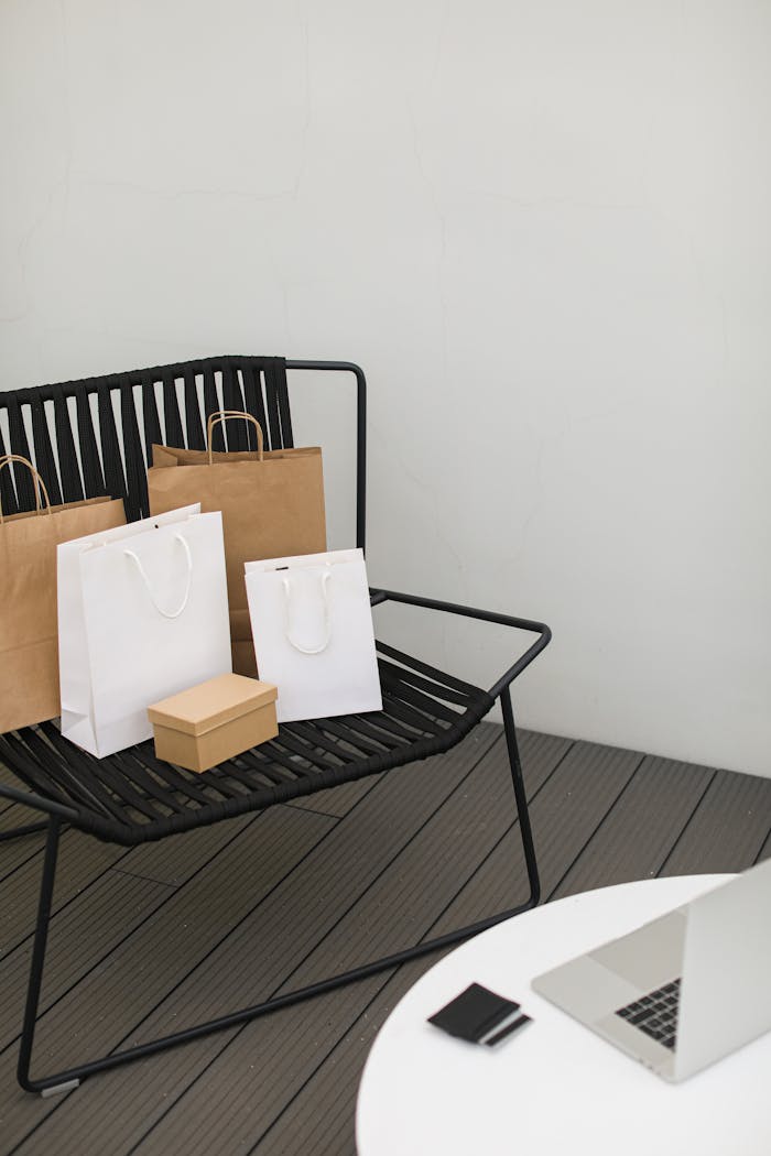 Shopping bags and laptop on chair, ideal for online shopping concepts.